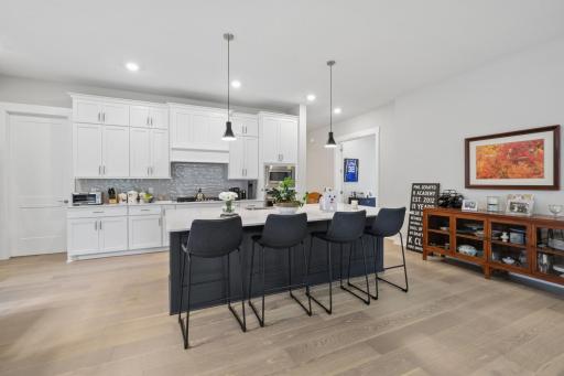 The spacious kitchen centers around a massive island topped with quartz countertops. Room for stylish stools for guests to enjoy breakfast, a casual meal, a fun happy hour.