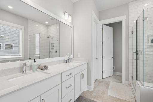 Primary bathroom also features dual sinks with a spacious vanity and large mirror, providing both convenience and ample space for daily routines.