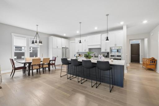 Kitchen with practical features like soft-close cabinetry, stainless steel appliances and durable hardwood flooring. The informal, relaxed dining area off to the left, perfect for family and friends to share a meal together. Bon Appetit