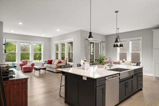 The dining area sits between the kitchen and living room, acting as the natural connector. Itâs open on all sides, with clear sightlines to the island and the fireplace.