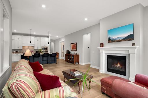 From the opposite side of the room, a large, comfortable sofa faces a sleek entertainment center with a wall-mounted TV.