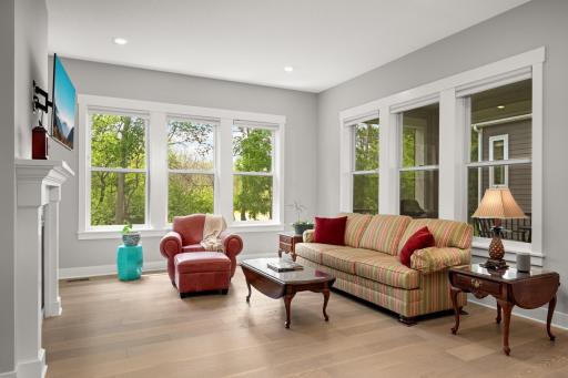 Another view of the living room showcasing its bright, open layout. Large windows fill the space with natural light, while the comfortable seating area, and seamless flow into the adjoining spaces.