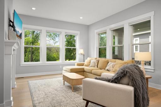 Spacious living room filled with natural light from large windows, featuring a cozy gas-burning fireplace that creates a warm and inviting atmosphere.