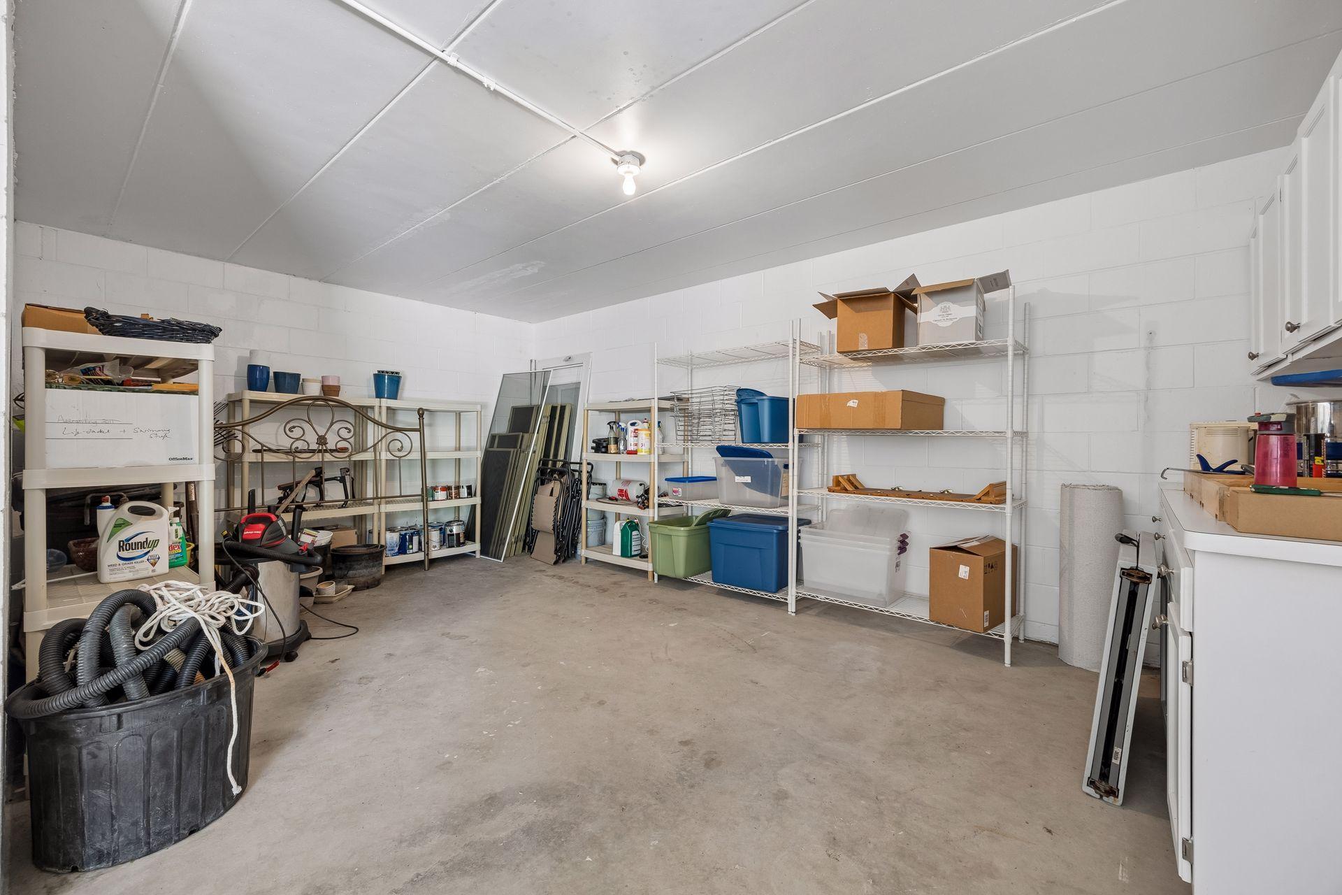 Additional 4th garage stall located at the back of the home, offering versatile space for a workshop, hobby or active space, or extra storage for yard equipment and more. **Note:** Carpet shown in the photo is not installed and will be removed.