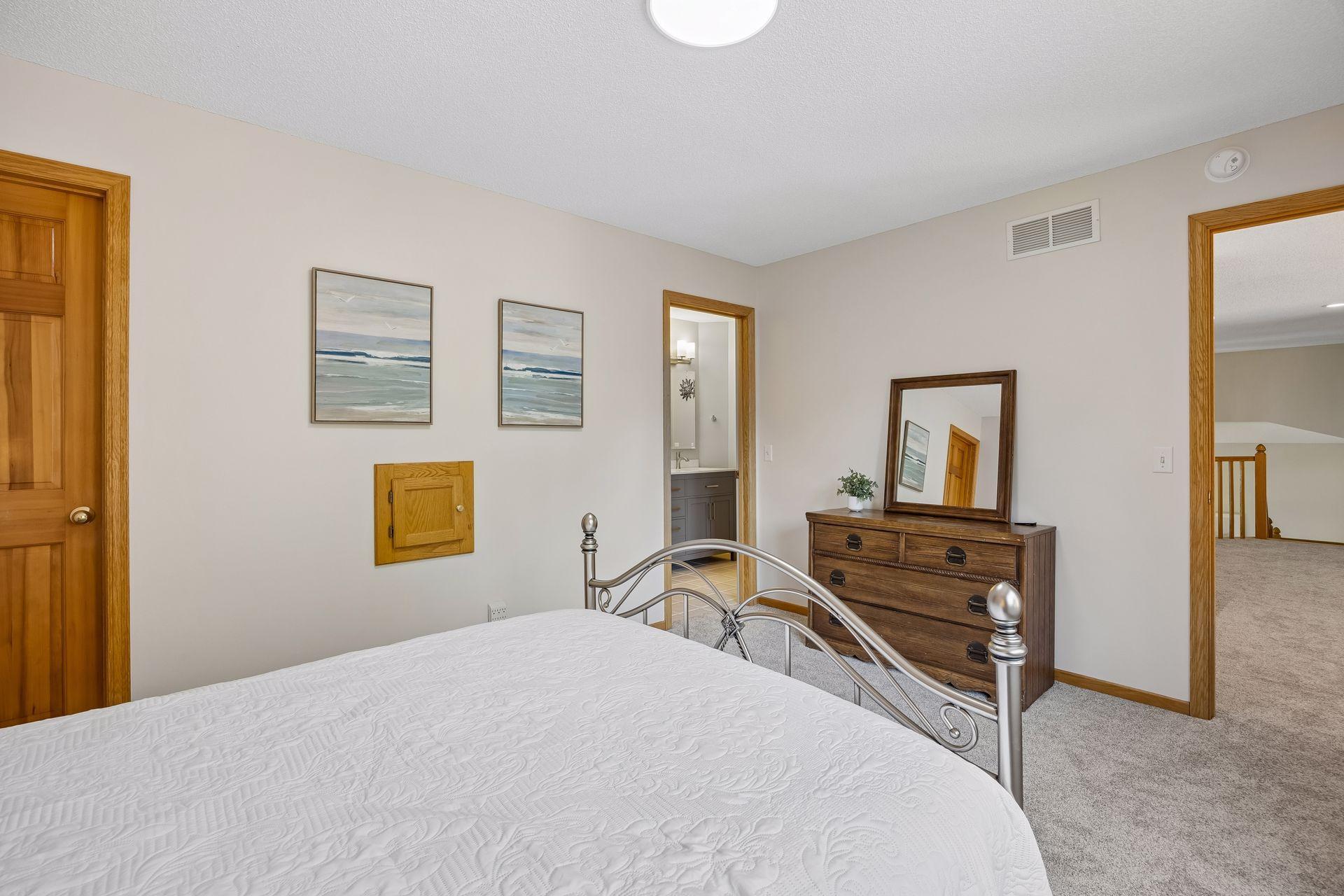 One of four spacious bedrooms on the upper level, featuring an attached bathroom and a large walk-in closet for added comfort and convenience.