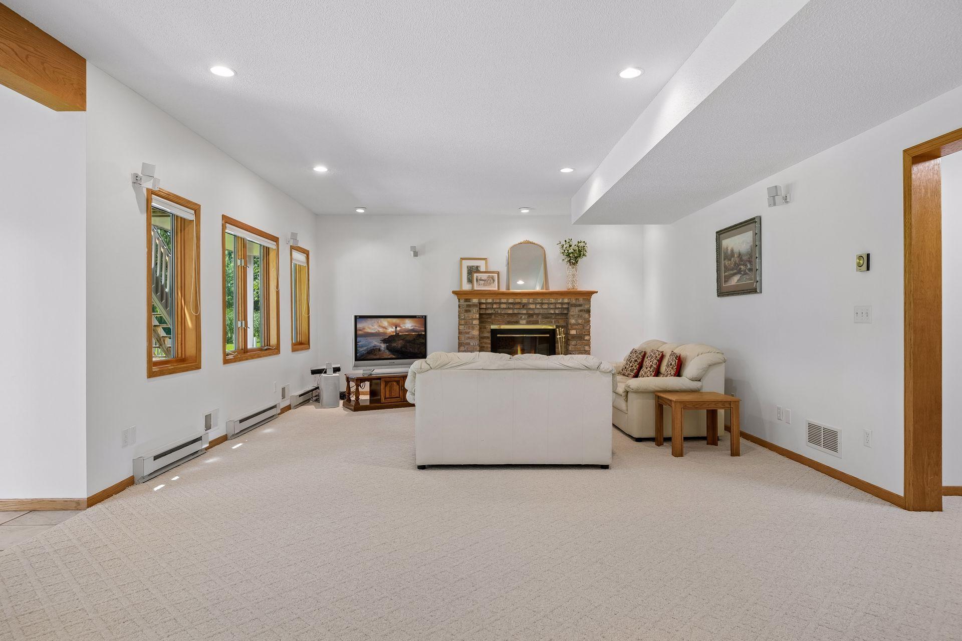 Spacious walkout lower level with high ceilings, a cozy fireplace, and wet bar—perfect for entertaining, relaxing, or additional living space.