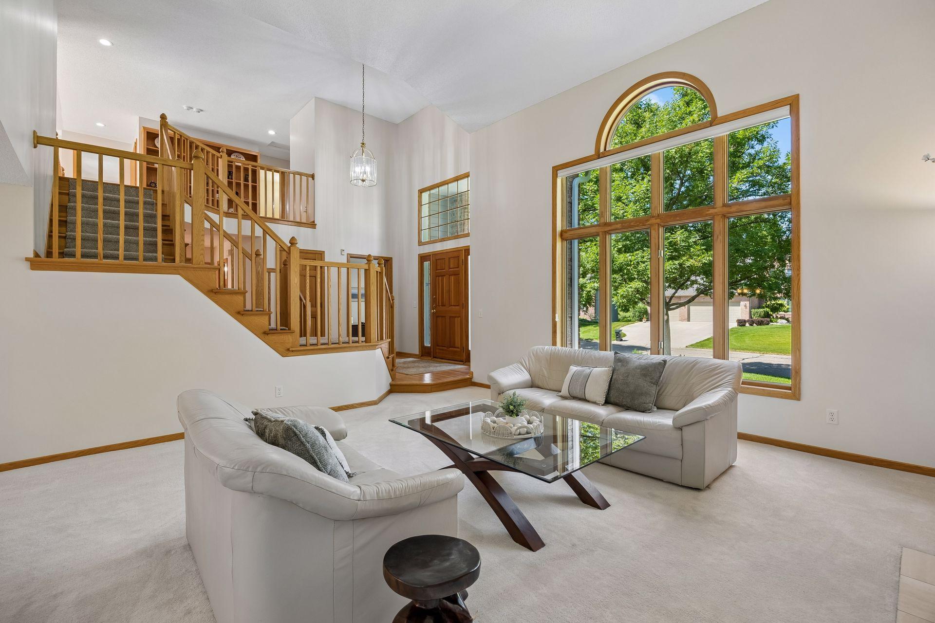 Spacious living room area designed for comfortable living and entertaining, with soaring two-story ceilings creating an impressive sense of space.