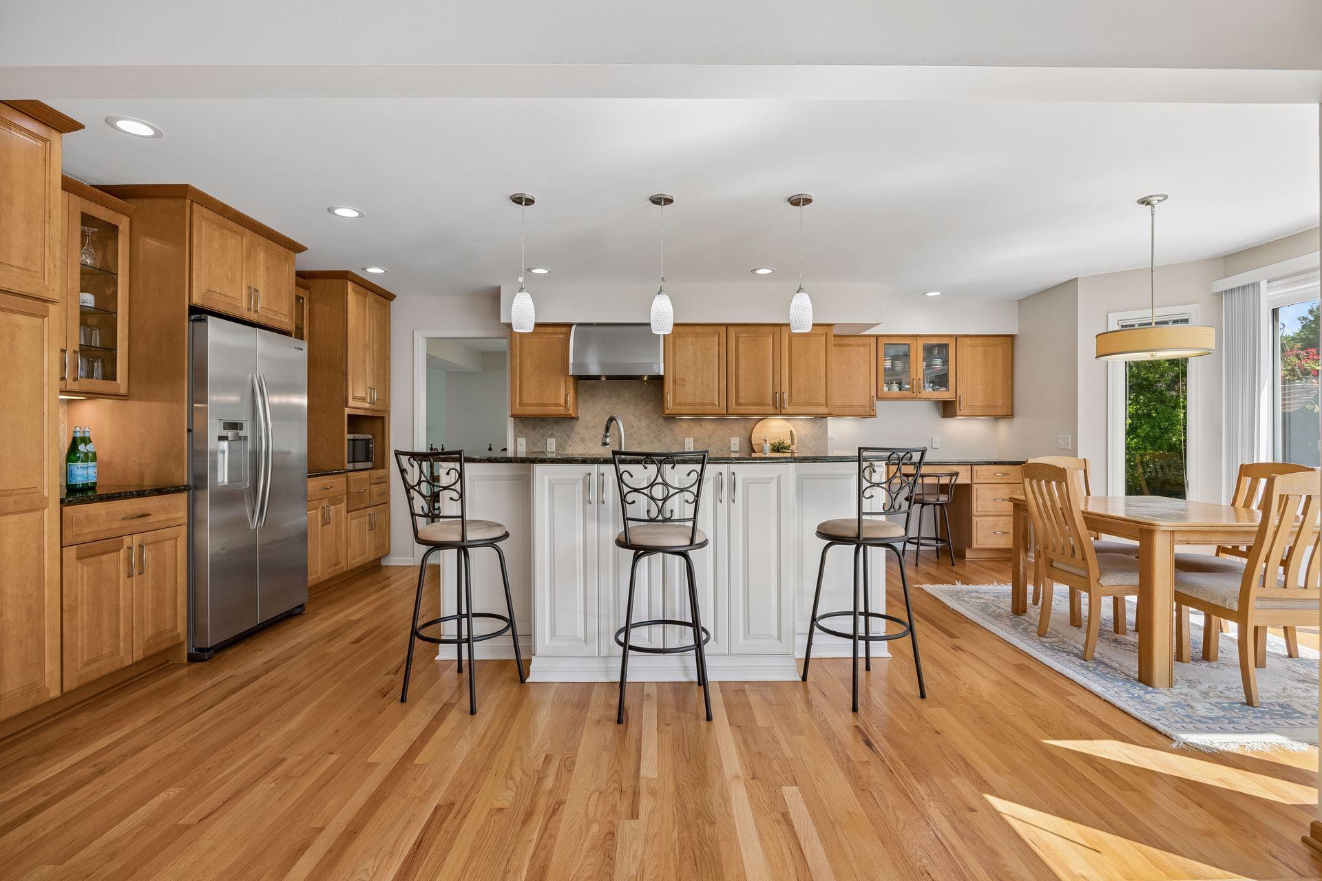 Open kitchen featuring stainless steel appliances, countertop seating, and an eat-in area. The seamless flow into the main living space creates an inviting layout for everyday living and entertaining.