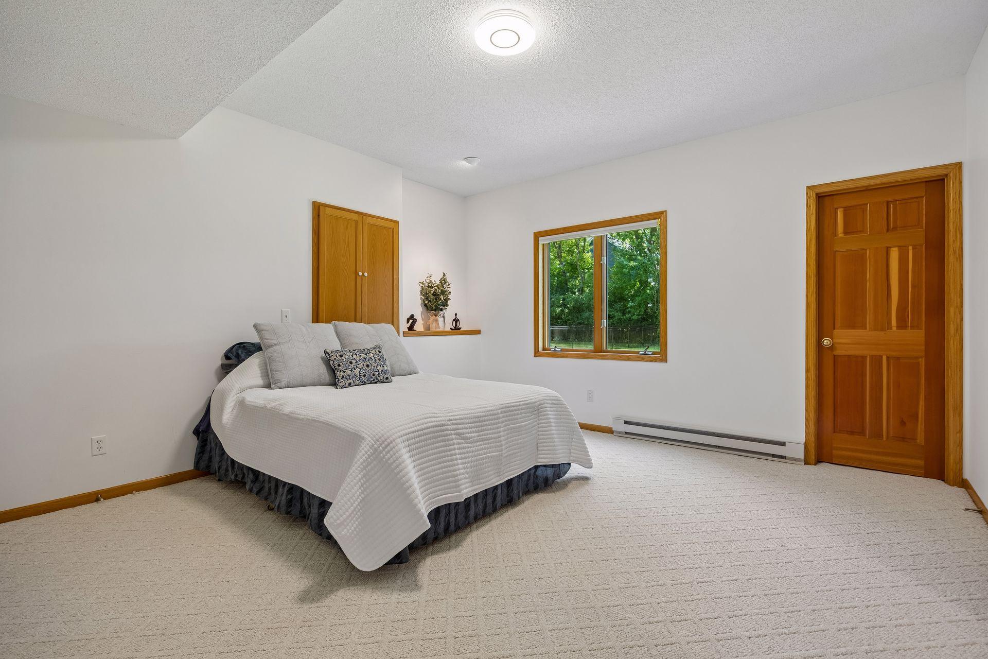 Spacious 5th bedroom in the lower level featuring high ceilings and a private setting.