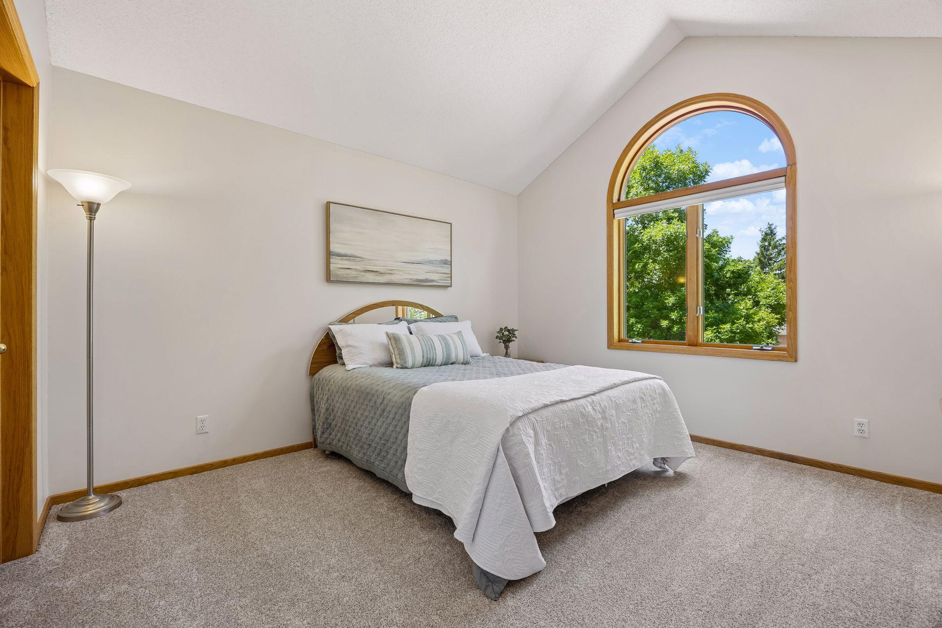 Large bedroom featuring vaulted ceilings, a generous walk-in closet, and abundant natural light for a bright and inviting retreat.