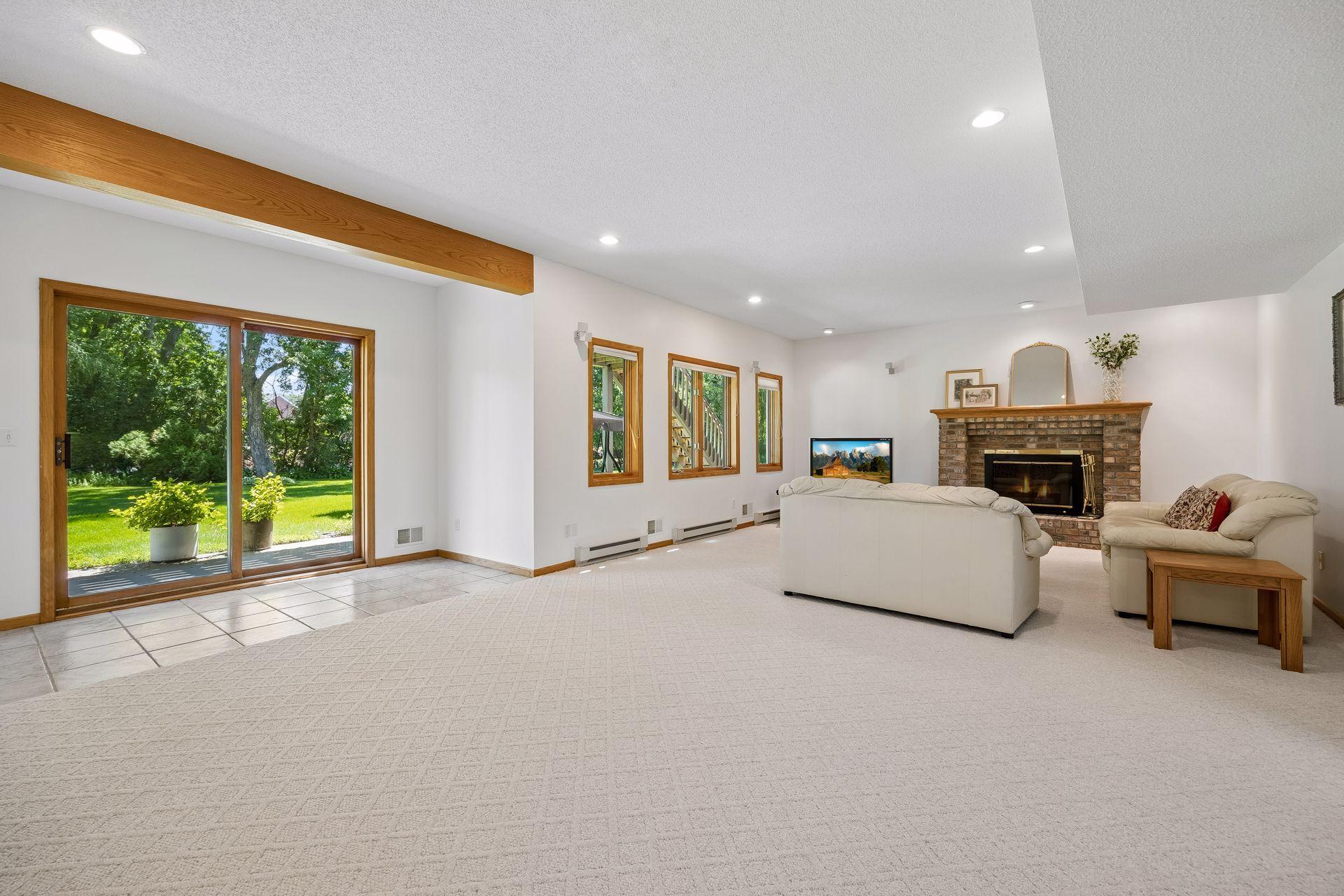 Spacious walkout lower level with high ceilings, a cozy fireplace, and wet bar—perfect for entertaining, relaxing, or additional living space.