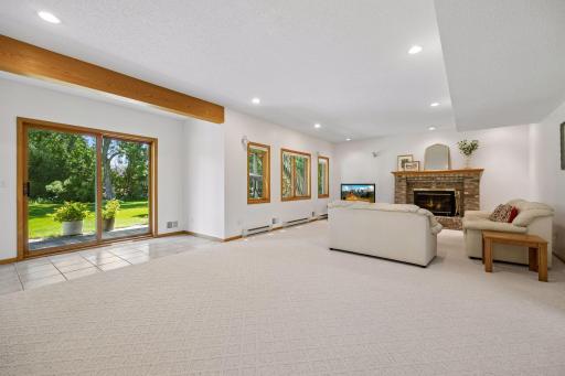 Spacious walkout lower level with high ceilings, a cozy fireplace, and wet barâperfect for entertaining, relaxing, or additional living space.