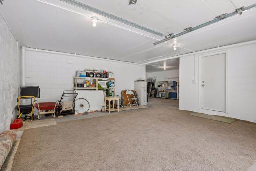 Additional 4th garage stall located at the back of the home, offering versatile space for a workshop, hobby or active space, or extra storage for yard equipment and more. **Note:** Carpet shown in the photo is not installed and will be removed.