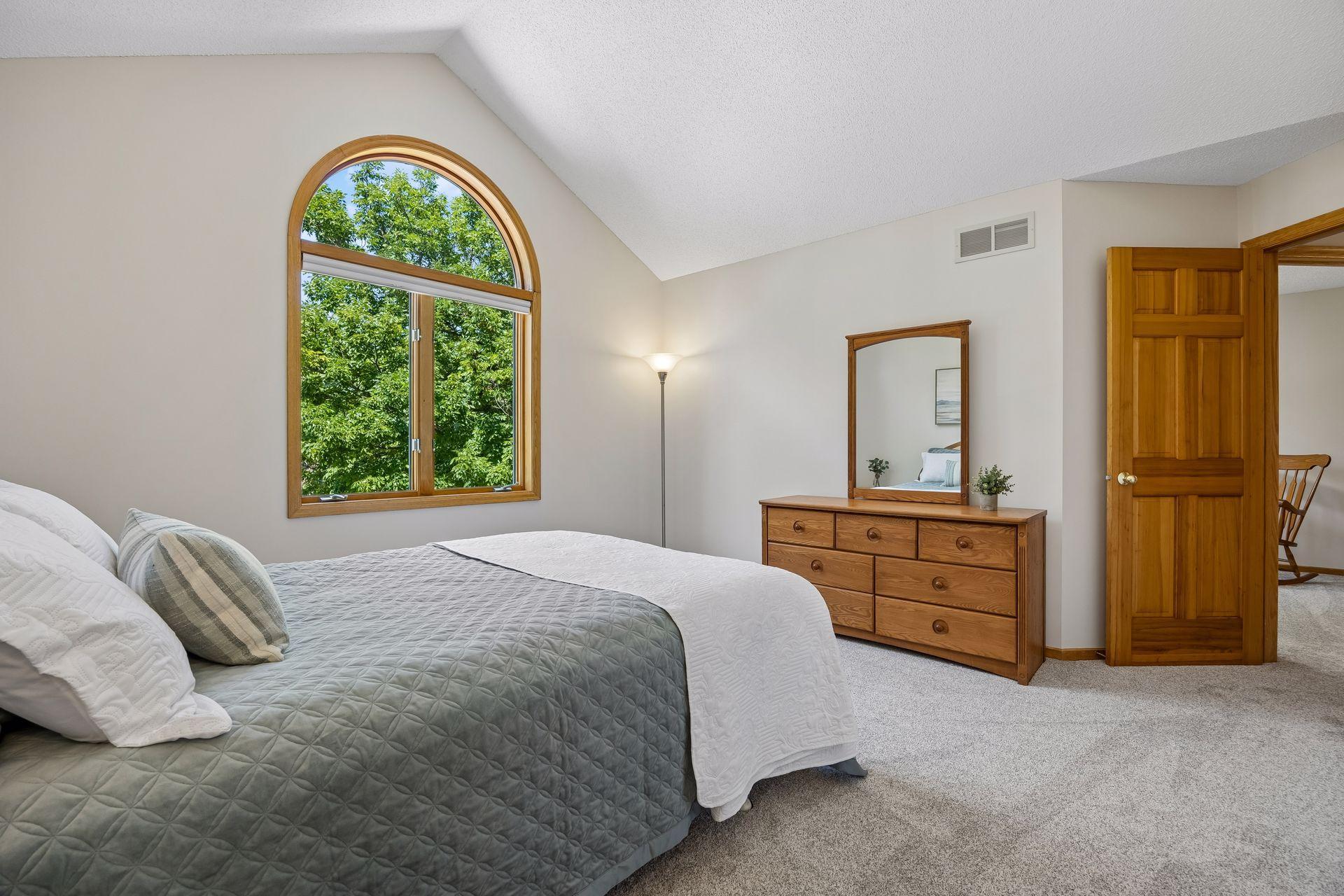 Large bedroom featuring vaulted ceilings, a generous walk-in closet, and abundant natural light for a bright and inviting retreat.
