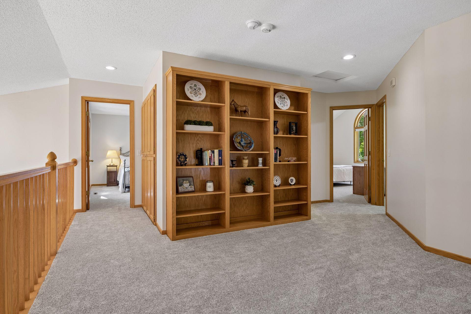 Expansive upper-level loft featuring a full wall of built-in bookshelves, adding character and providing plenty of space for books, décor, or storage.