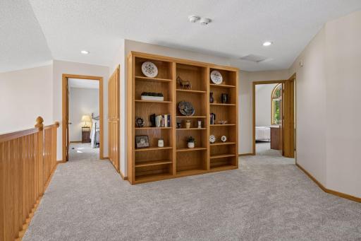 Expansive upper-level loft featuring a full wall of built-in bookshelves, adding character and providing plenty of space for books, dÃ©cor, or storage.