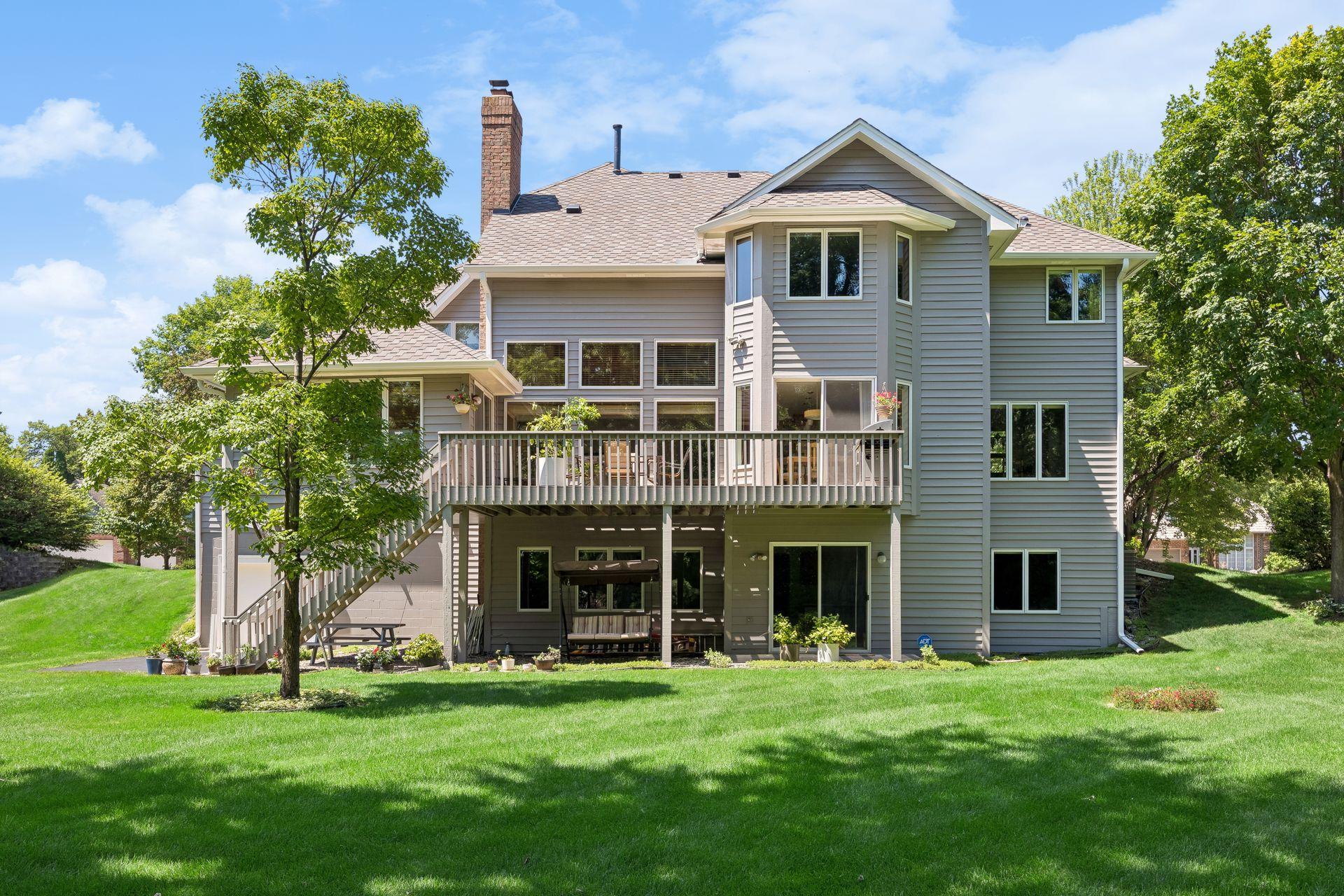Large, flat, private backyard surrounded by mature trees, offering a peaceful setting with plenty of space for outdoor living, entertaining, and recreation.