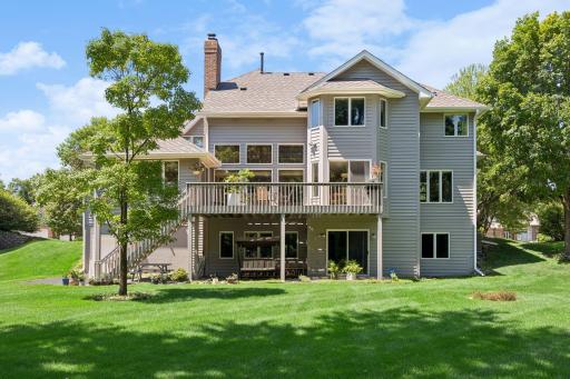 Large, flat, private backyard surrounded by mature trees, offering a peaceful setting with plenty of space for outdoor living, entertaining, and recreation.