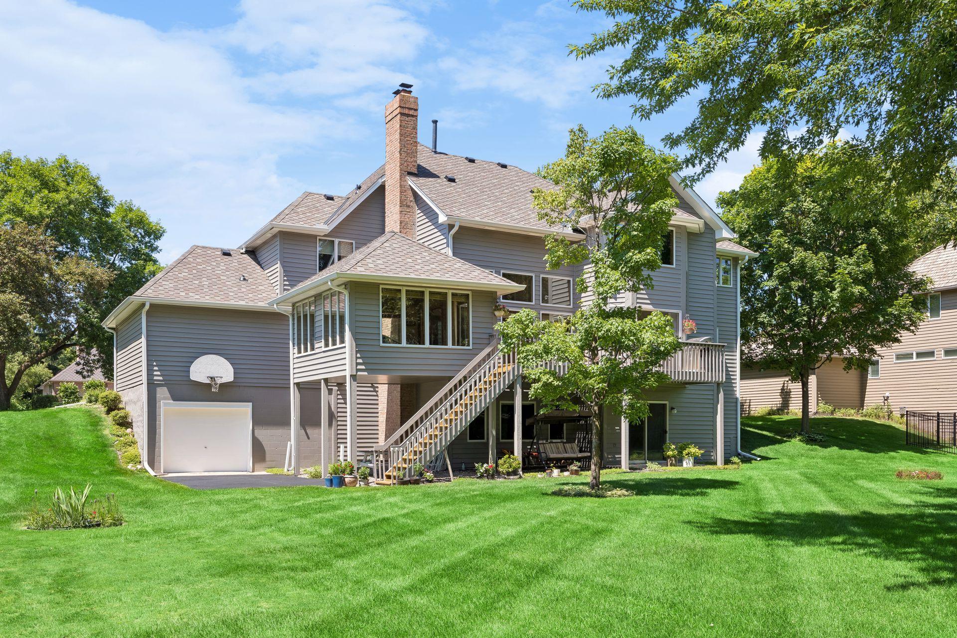 Large, flat, private backyard surrounded by mature trees, offering a peaceful setting with plenty of space for outdoor living, entertaining, and recreation.