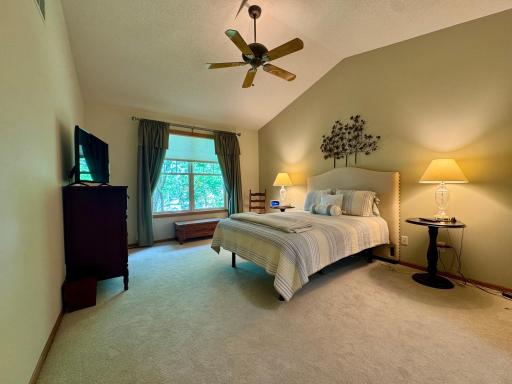 The primary suite is well appointed with vaulted ceilings and private nature views.
