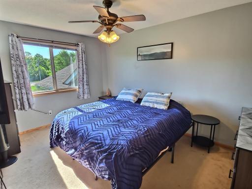 The first of the two upper-level bedrooms includes carpet floors, a ceiling fan and nice sized closet.