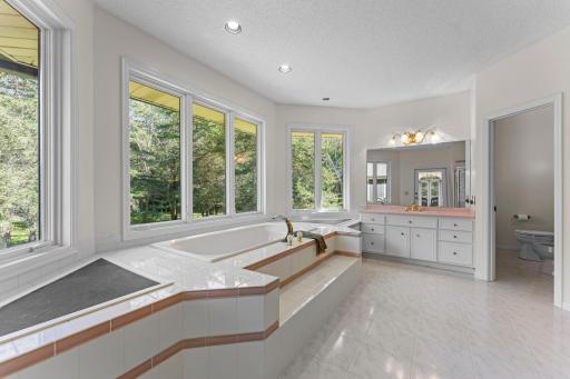 This primary ensuite that has a door to the deck is the DEFINITION of luxury