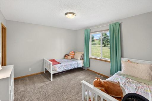 Overlooking the peaceful green space behind the home, this bedroom feels bright, comfortable, and inviting.