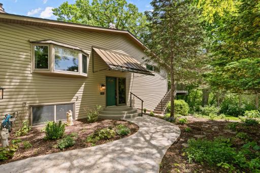 Charming front entry tucked among mature trees and perennial landscaping that creates a private retreat feel as you enter your home