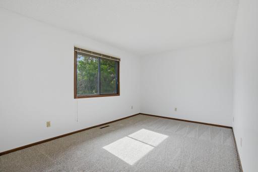 Primary bedroom, window view, new carpet, fresh paint.