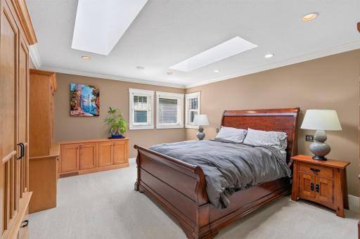 The upper-level primary suite is filled with natural light, where skylights, custom built-ins, and timeless craftsmanship create a warm and inviting retreat.