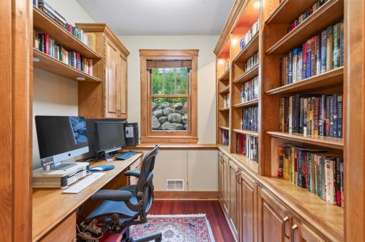 Conveniently located on the main level, this distinguished office showcases beautiful custom built-ins and rich cabinetry, creating a workspace as functional as it is elegant.