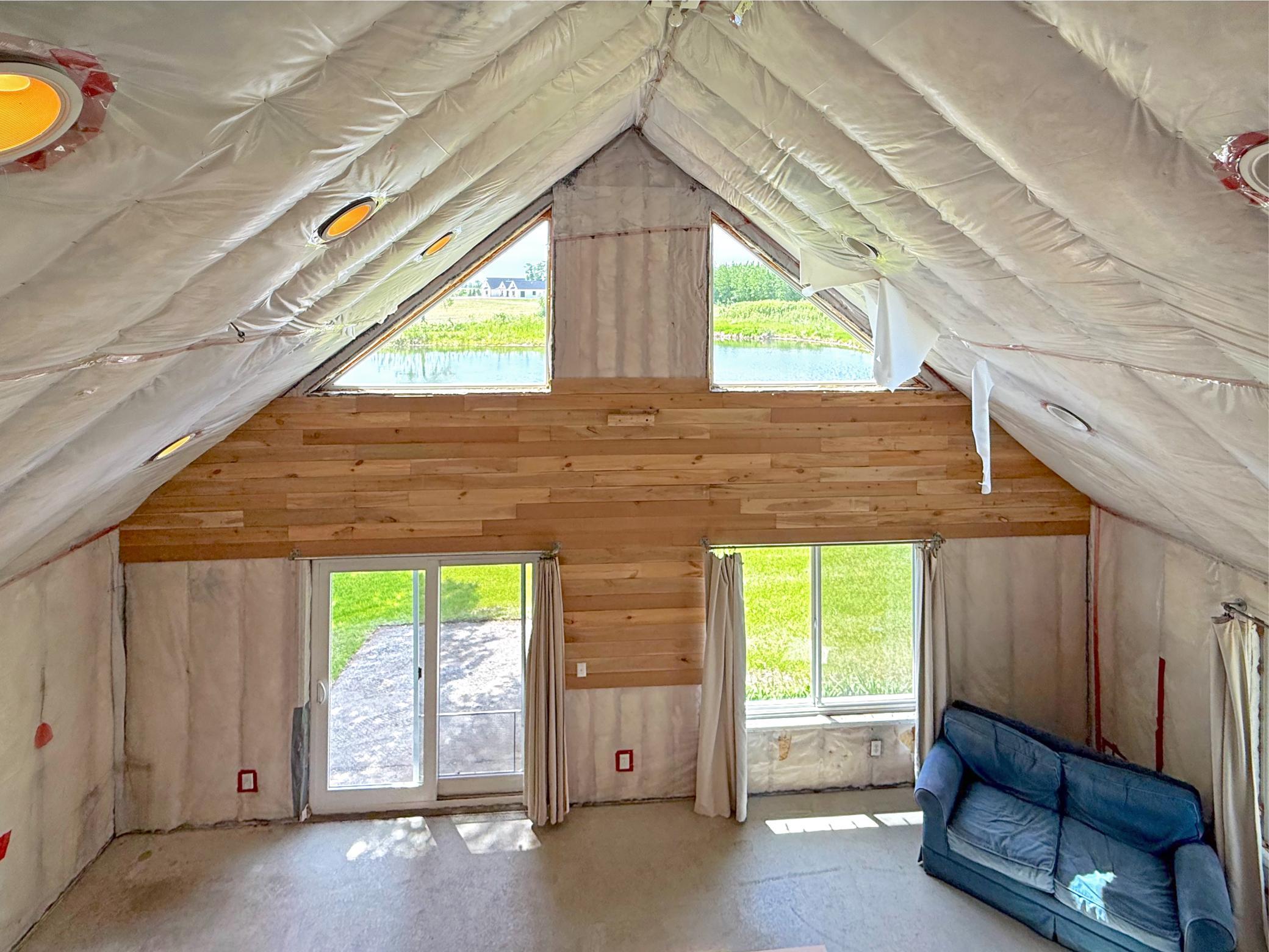 A large window brings in natural light and captures views of the surrounding mature trees, while the open design creates endless possibilities.