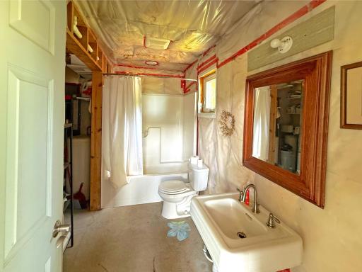 The bathroom is already equipped with a tub/shower combination, vanity, and plumbing fixtures, providing a solid foundation for future completion.
