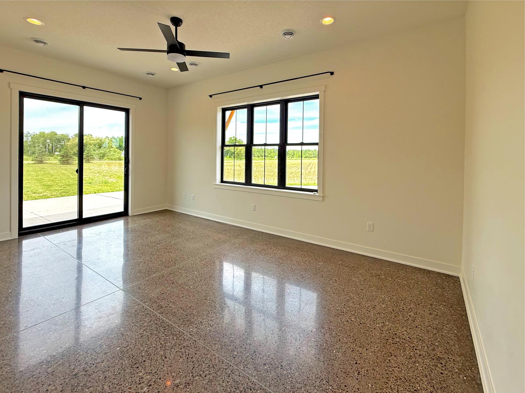 The spacious main-level primary suite is designed as a private retreat while enjoying peaceful country views through direct access to the outdoor patio.