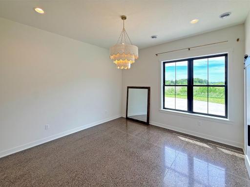The second main-level bedroom offers an inviting space for family or guests, featuring large windows that capture beautiful countryside views.