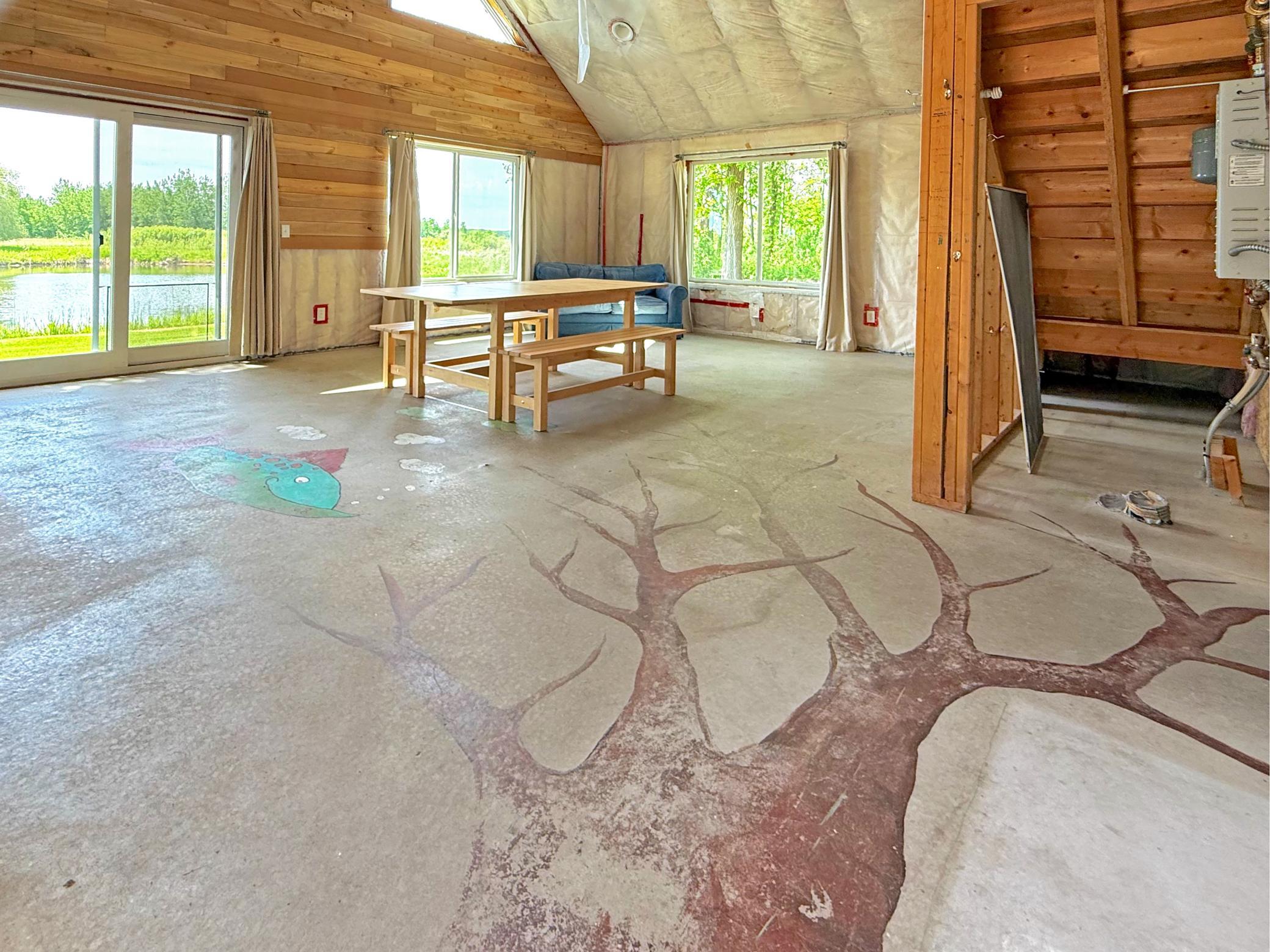 Large windows overlook the pond and surrounding mature trees, while the open-concept layout offers flexibility to create an entertaining space or private getaway.
