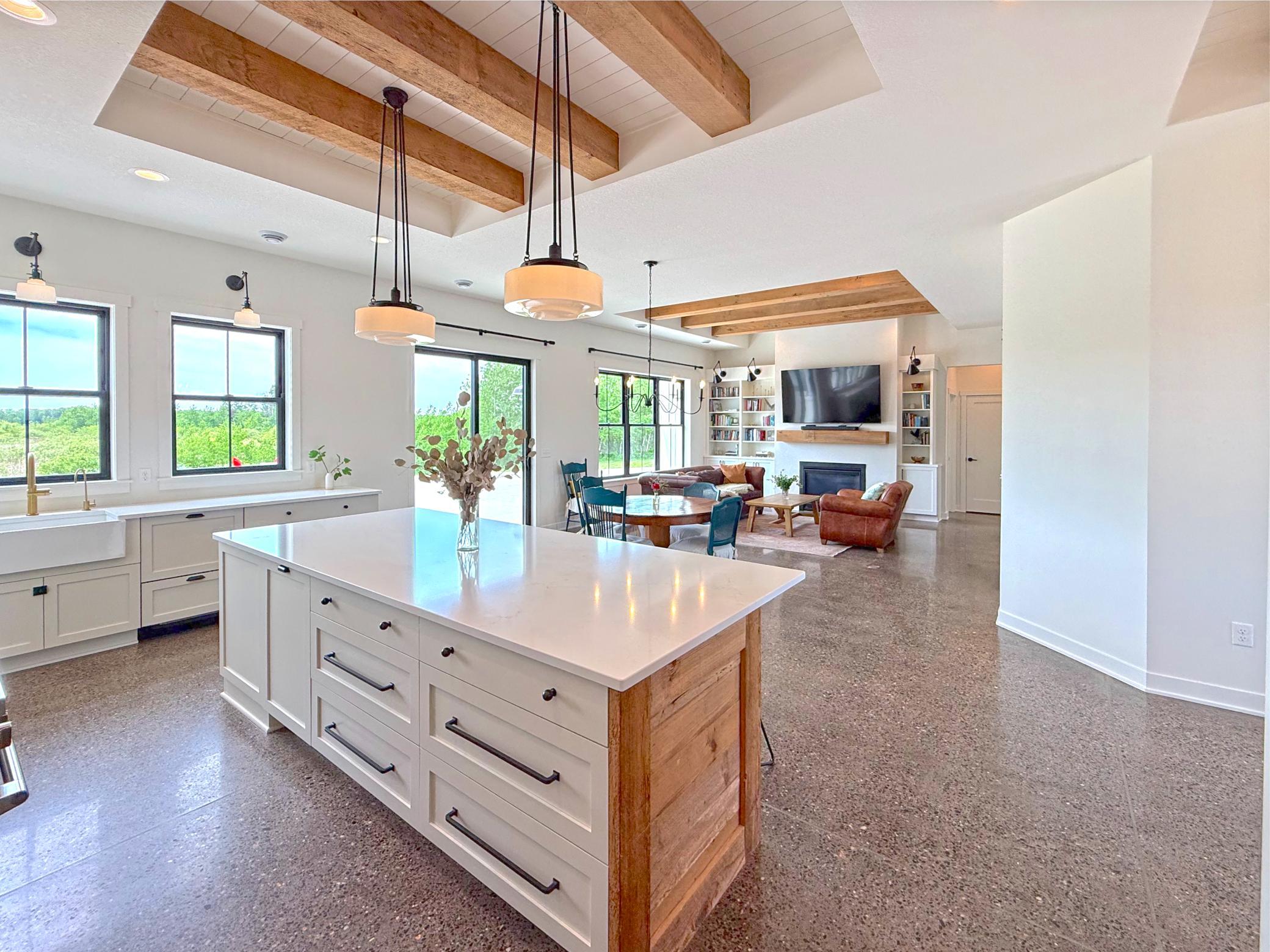 Overhead, reclaimed wood beams and beadboard ceiling details add character and craftsmanship, while the open-concept design flows seamlessly into the living area.