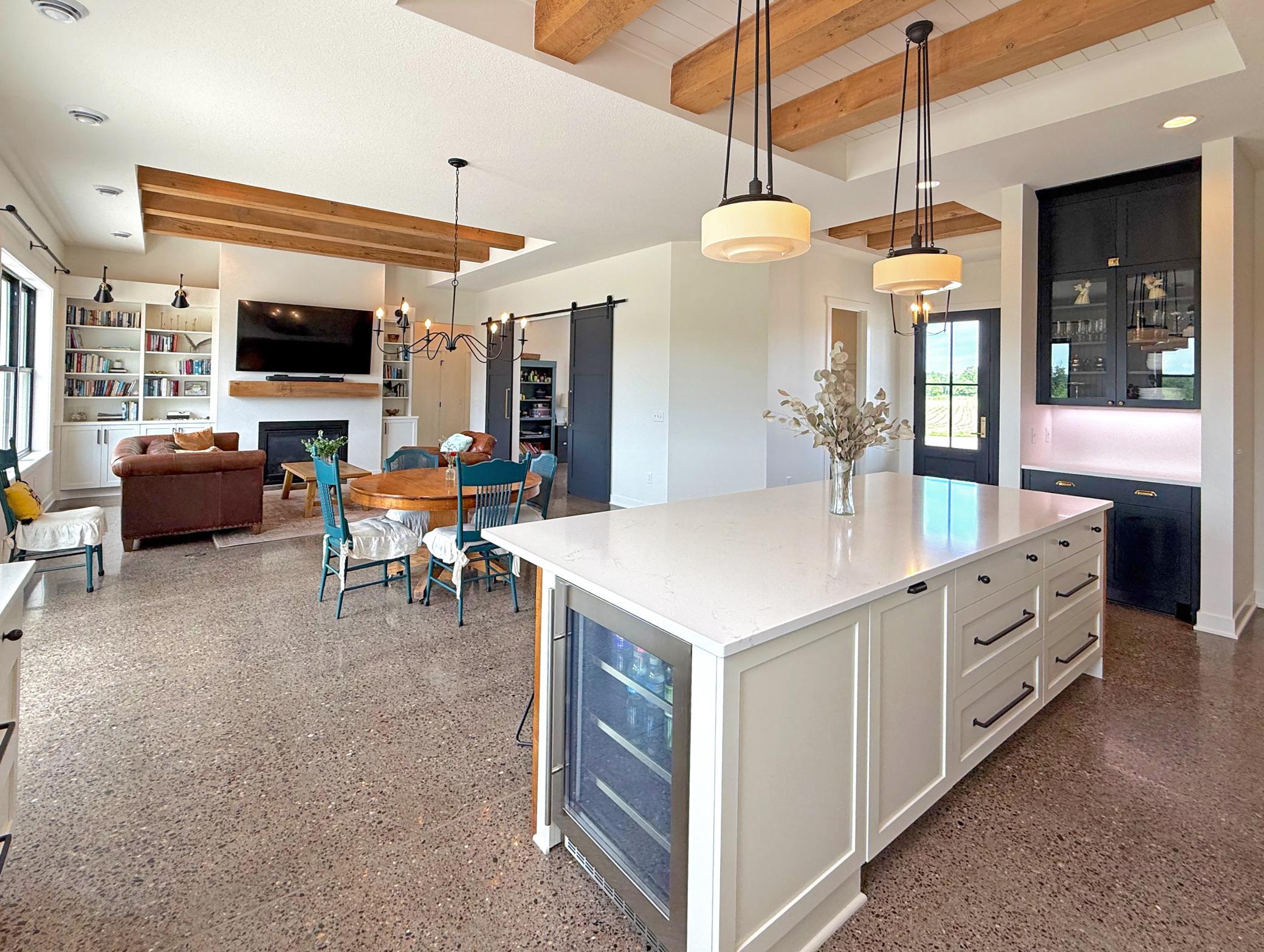 Reclaimed wood beams, beadboard ceiling details, and custom finishes showcase a seamless fusion of farmhouse-inspired charm and contemporary elegance.