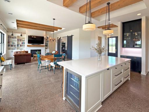 Reclaimed wood beams, beadboard ceiling details, and custom finishes showcase a seamless fusion of farmhouse-inspired charm and contemporary elegance.
