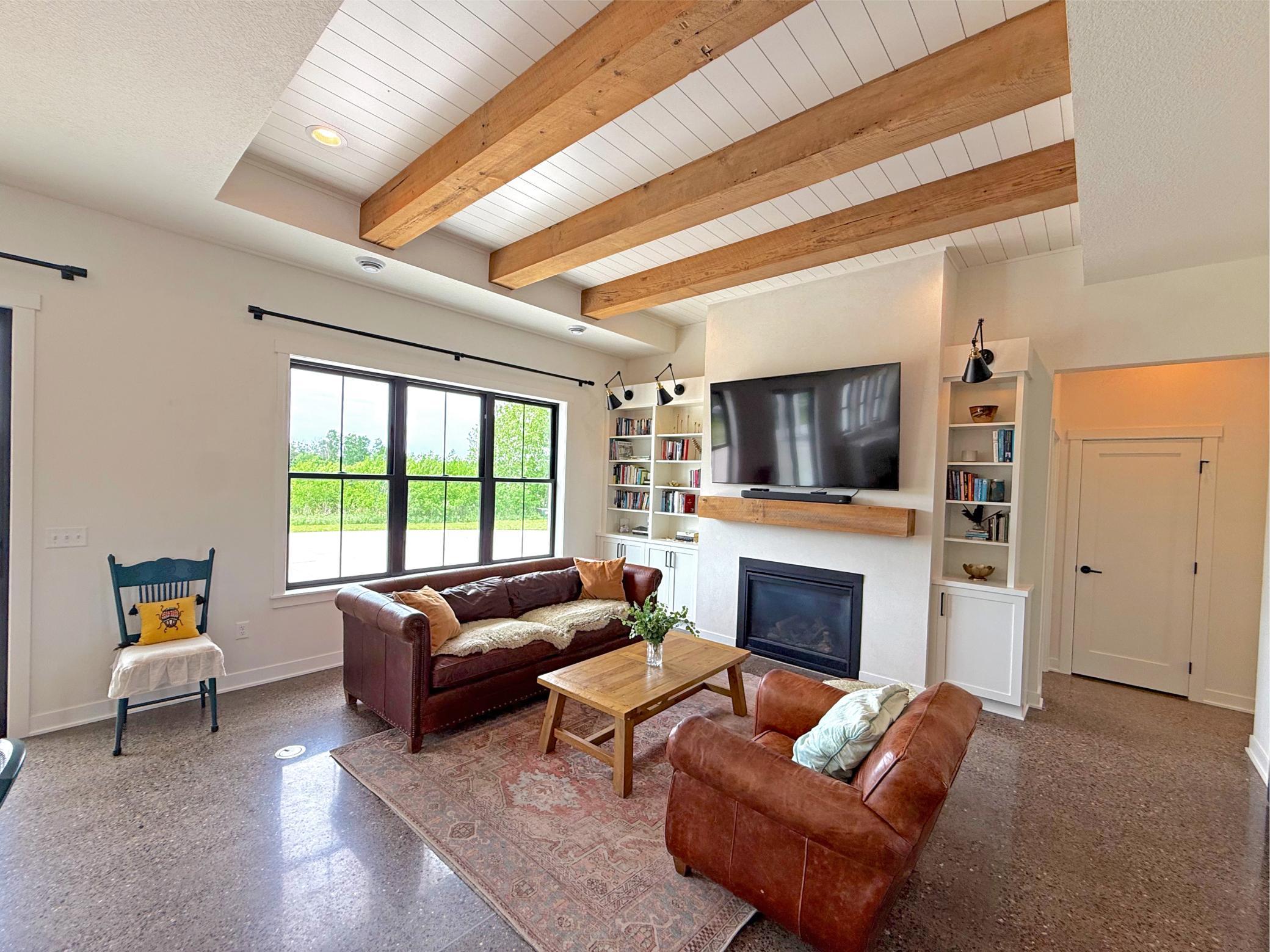 The living room offers a warm and inviting gathering space highlighted by a beautiful gas fireplace flanked by custom built-in shelving and cabinetry.