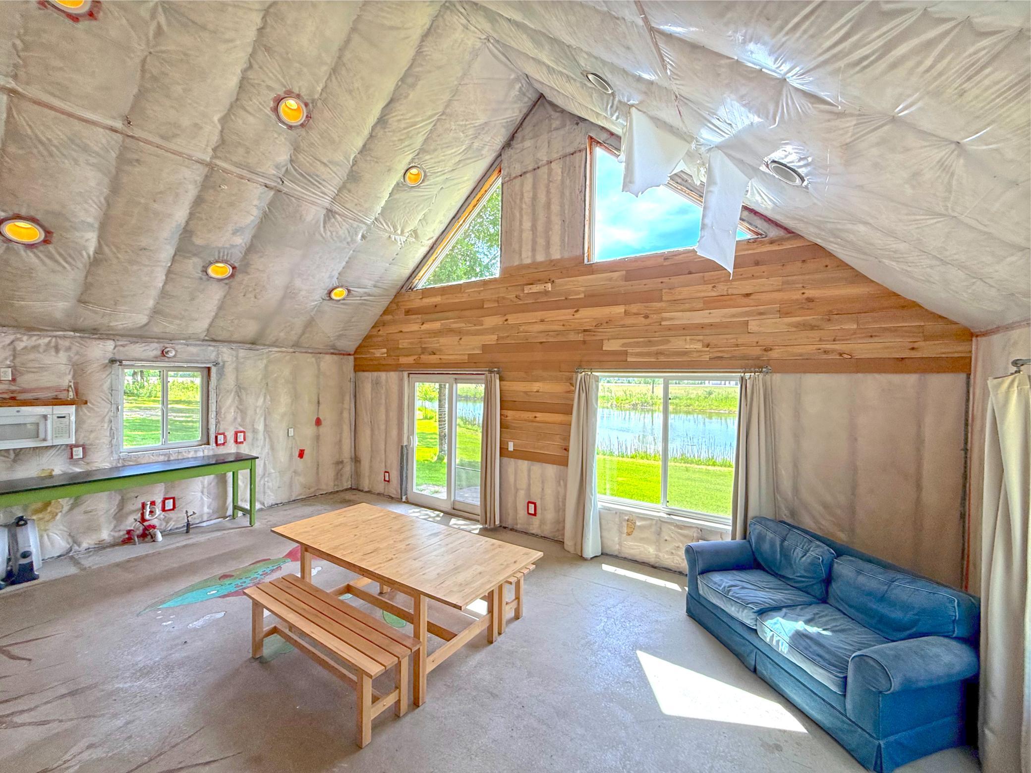 With soaring vaulted ceilings, expansive windows, and sliding glass doors that frame peaceful water views, the space is filled with natural light.