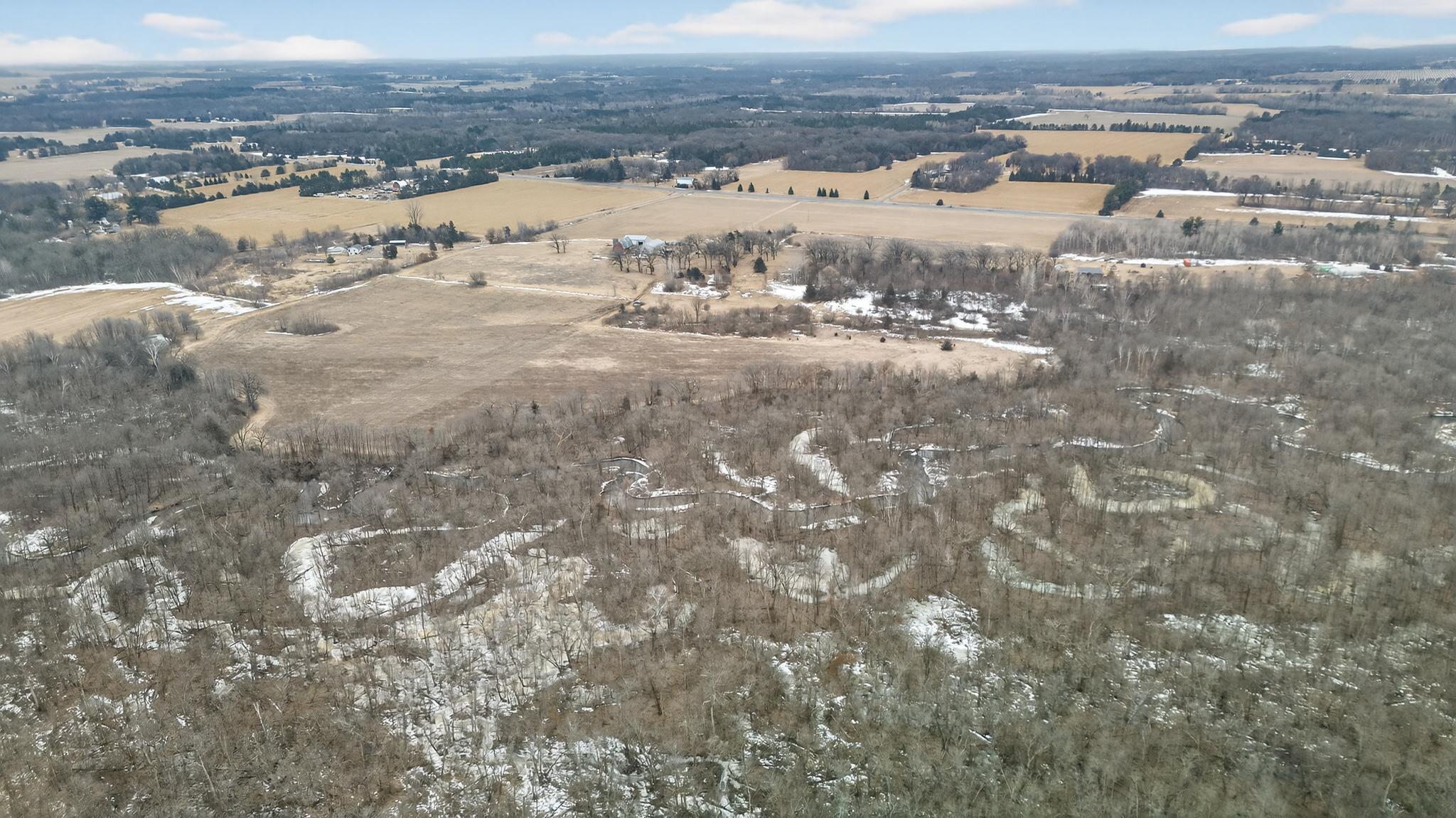 Expansive aerial perspective capturing rolling acreage, mature trees, and stretches of the Sunrise River. Total of 3 - 20-acre parcels available.