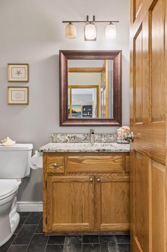 Main floor powder room with slate tile floor and granite counter.
