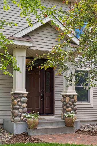 Welcoming entry with stone accent pillars and paver sidewalk.