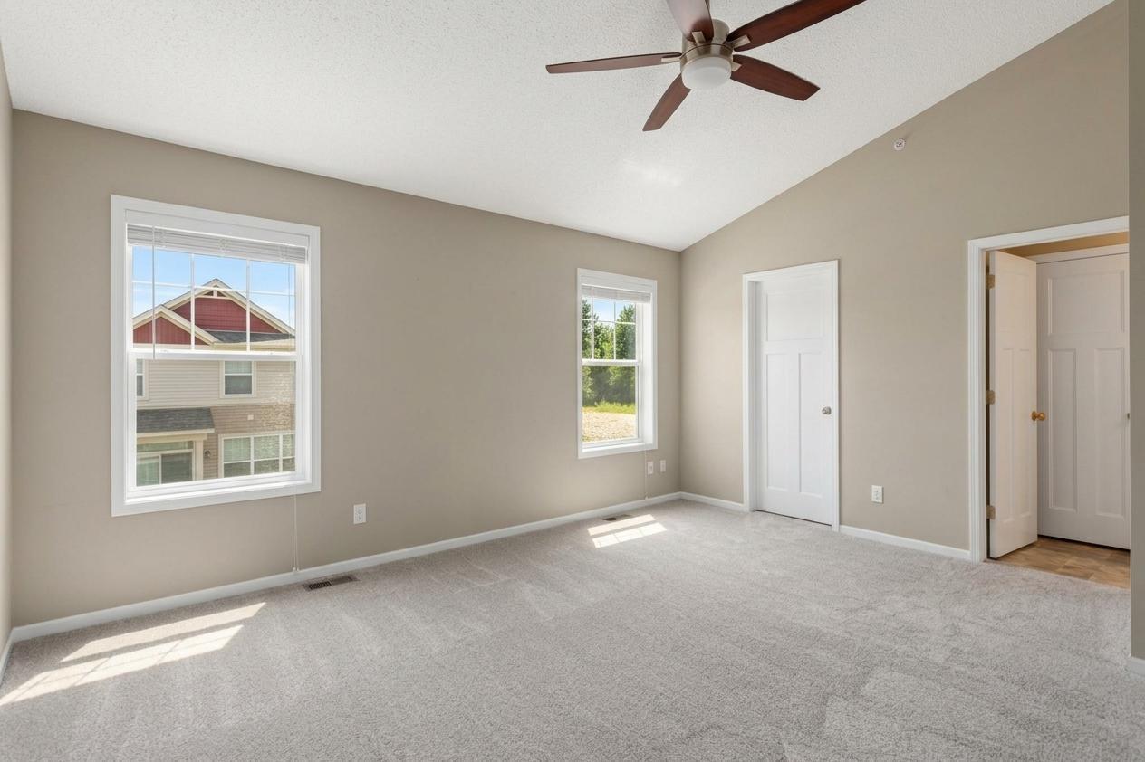 Spacious primary suite featuring vaulted ceilings, a generous walk-in closet and private full bathroom.
