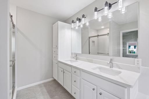 Gorgeous primary bath with dual vanity, quartz countertops and storage closet.