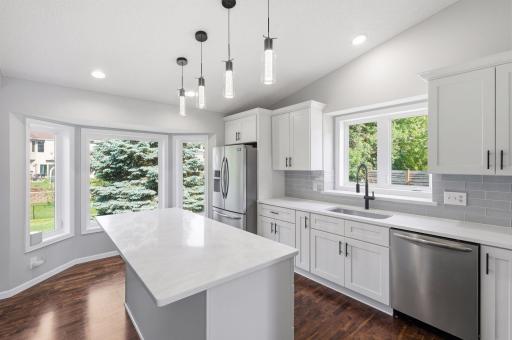 The kitchen boasts stylish quartz countertops and a glass subway tile backsplash.