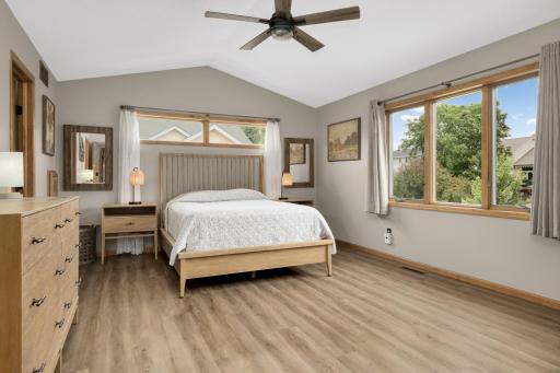 Spacious Owner's Suite with vaulted ceiling, updated flooring, and large windows overlooking the backyard.