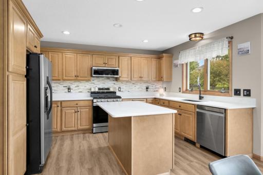 Spacious Kitchen with abundant cabinetry, Quartz countertops, updated backsplash, Center Island, and Stainless Steel appliances.