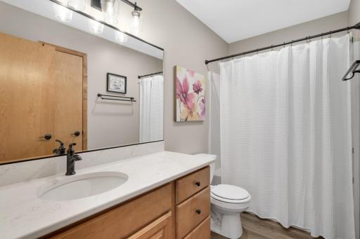 Spacious Full Bath with Quartz countertop, updated lighting, and a large vanity offering plenty of storage.